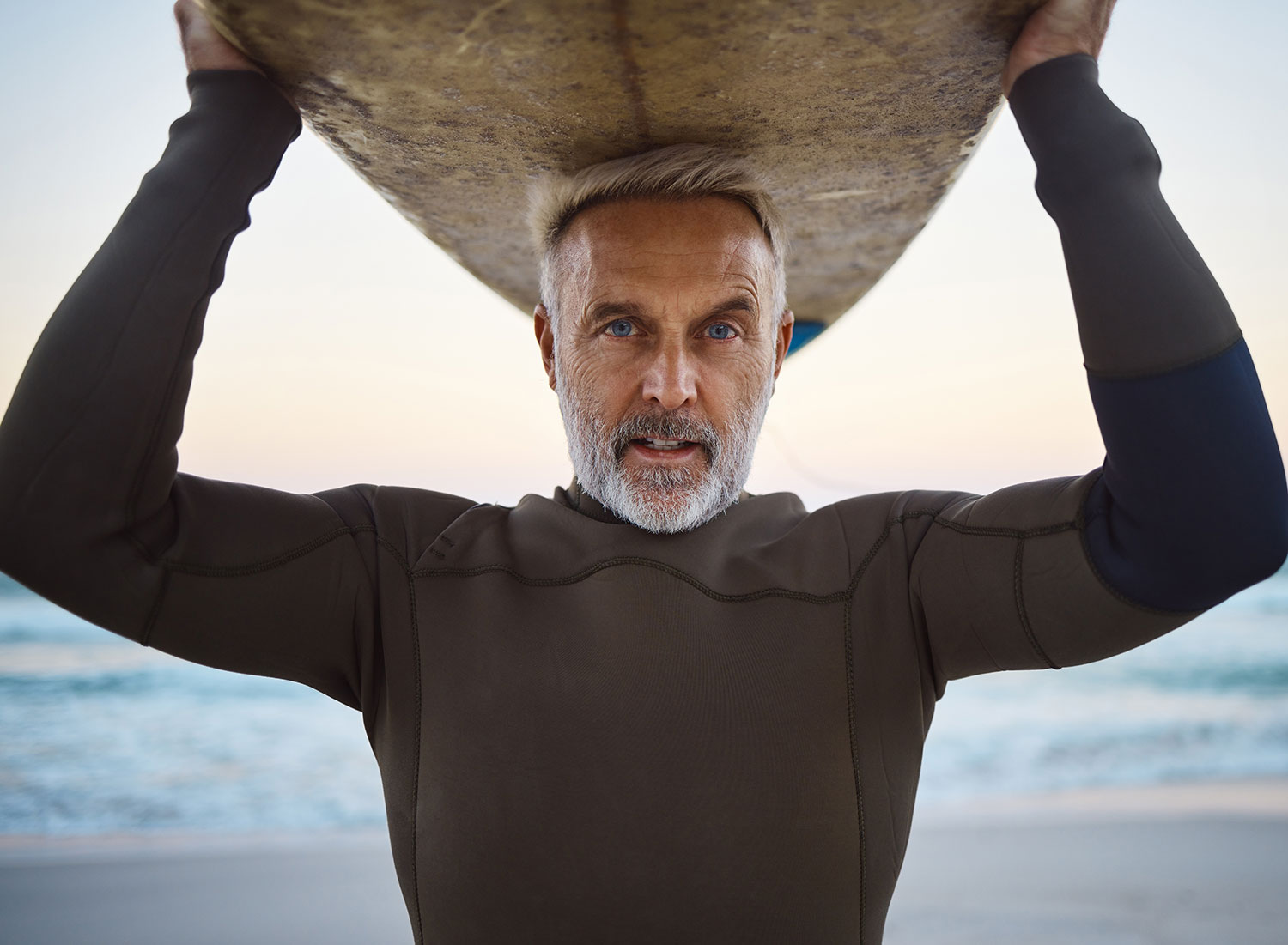 older man with surfboard on top of head