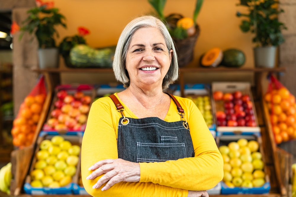 smiling woman by fruit stand