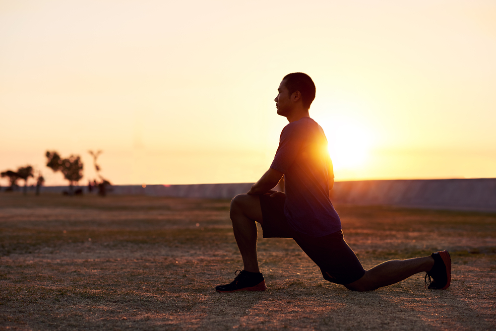 man stretching in field