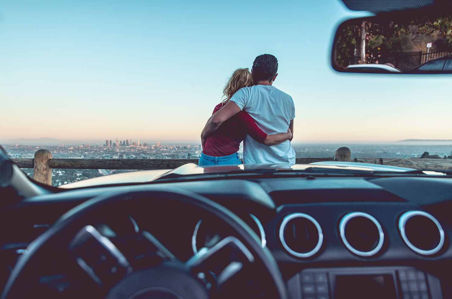 sitting on hood of car staring at city